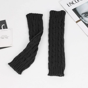 Detail of black cable-knit long fingerless gloves in warm acrylic yarn texture