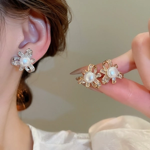 Detail of ribbon bow stud earrings with white pearls and micro-pave cubic zirconia crystals
