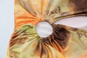 Close-up of metal ring hardware and gathered fabric detail on summer floral dress