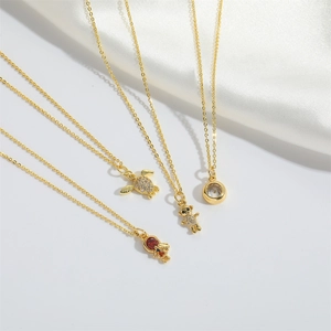 Golden necklace collection with bear and turtle pendants on elegant white silk fabric