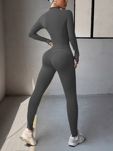 Vue arrière d'un ensemble de yoga gris foncé avec legging taille haute et passe-pouces