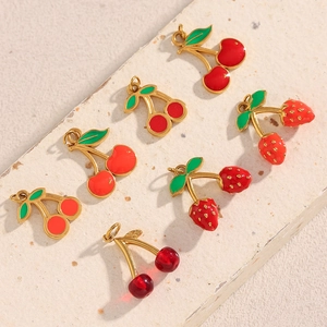 Detailed view of red cherry and strawberry charms with 18K gold plating for DIY jewelry