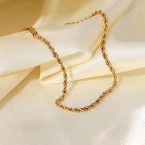 Elegant 2mm gold twisted rope anklet in titanium steel displayed on white silk fabric