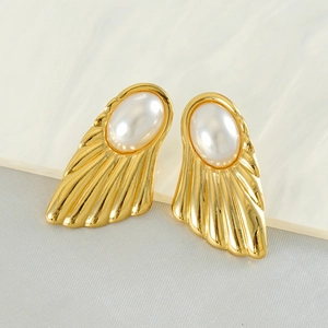 Vintage gold fan-shaped stud earrings with pearls on marble and grey background