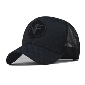 Detail of black trucker hat featuring diamond quilted fabric and breathable mesh back