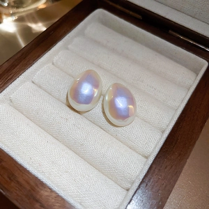 Détail macro de boucles d'oreilles perles goutte d'eau avec éclat nacré iridescent