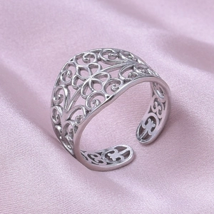 Gros plan d'une bague en acier avec motifs floraux ajourés et anneau réglable