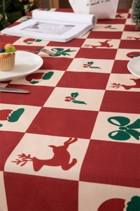 Detailed pattern of festive Christmas tablecloth with reindeers and red checkered design
