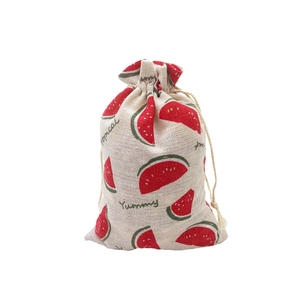 Detail of a beige linen drawstring bag featuring cute red watermelon prints and Yummy text