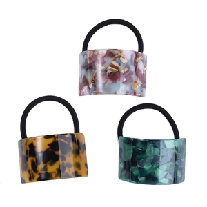 Three acetate hair ties in tortoiseshell, emerald green and floral patterns for women