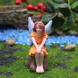 Statuina fata dei fiori in miniatura su ceppo con ali blu e vestito arancione per giardino