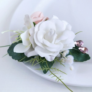 Boutonnière élégante avec rose blanche, feuilles vertes et gemmes violettes