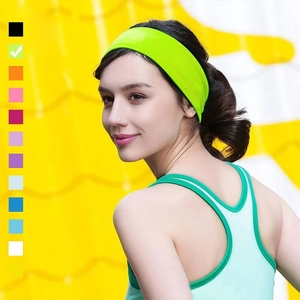 Detail of wide neon green high-elasticity sports headband worn by a fitness model