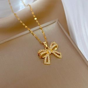 Detailed close-up of a golden butterfly necklace with sparkling zircon pavé on soft fabric