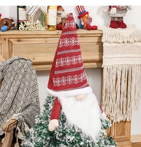 Close-up of a festive faceless gnome Christmas tree topper with red snowflake hat and white beard