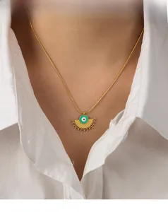 Detailed view of sunburst fan pendant with green evil eye and gold snake chain