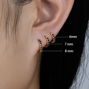 Detailed macro view showing 6mm, 7mm, and 8mm gold earrings with black zircon stones