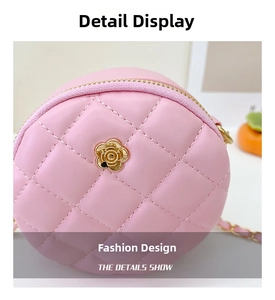 Detail of pink quilted crossbody bag with golden flower charm and metal chain strap