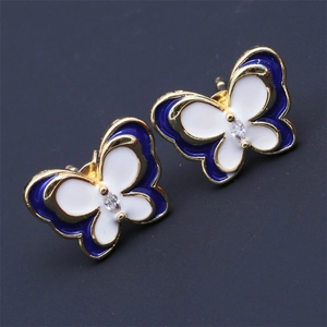 Close-up of blue and white enamel butterfly earrings with gold plating and center crystal