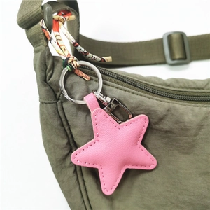 Close-up of pink star-shaped leather bag charm with hand-stitched details and silver clasp