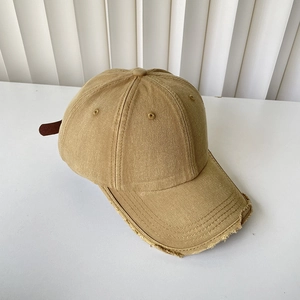 Detailed close-up of a vintage washed baseball cap featuring frayed edges and a cotton texture