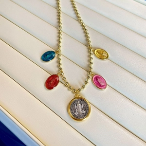 Close-up of gold bead necklace with colorful religious Virgin Mary enamel medals