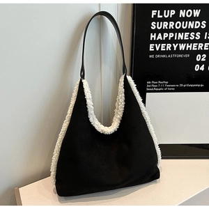 Close-up of black plush shoulder tote bag with white faux fur trim and sleek strap