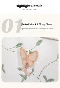 Detail of butterfly metal clasp and floral embroidery on white leather camera bag