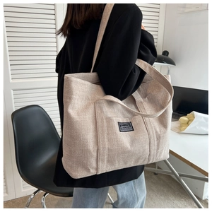 Close-up of beige canvas tote bag with fashion patch shown in a lifestyle setting