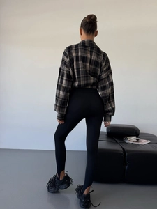 Retro oversized plaid shirt with black leggings and platform sneakers from back view