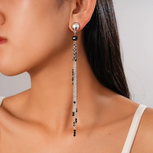 Detail of silver chain tassel earrings with black faceted beads on female model