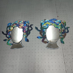 Detailed view of Medusa stained glass mirrors with colorful snakes on a workbench