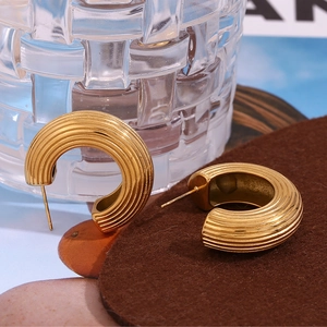Détail de boucles d'oreilles en C plaquées or 18 carats avec texture striée