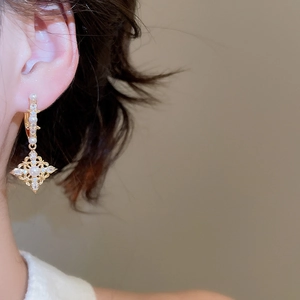 Detailed close-up of vintage 18K gold plated earrings with pearls and zircons on ear