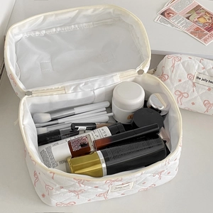 White quilted cosmetic bag set with pink bow pattern for travel and makeup storage