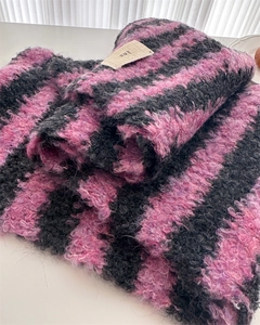 Close-up of soft black and pink striped wool scarf with fuzzy texture and ins label