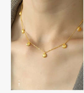 Close-up of gold shell pendant necklace elegantly worn on a woman's neck