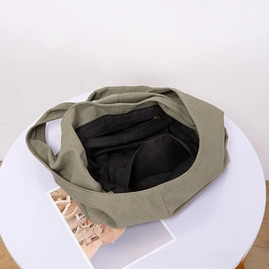 Top view detail of the olive green canvas tote bag interior with black fabric lining