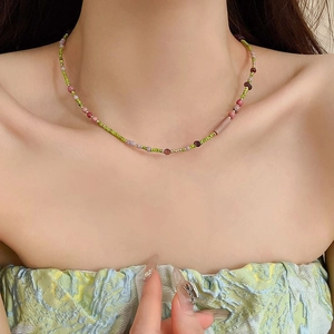 Detailed view of colorful agate and pearl necklace on a woman's collarbone