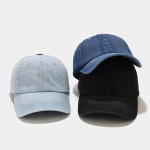 Close-up of denim baseball caps in light blue, dark blue, and black showing fabric texture