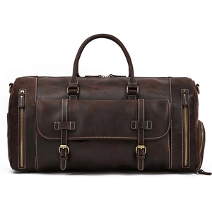 Detail view of a vintage dark brown leather duffel bag with buckled front pocket