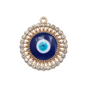 Macro view of a gold Evil Eye pendant with blue enamel and sparkling rhinestones