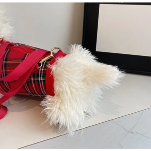 Detail of red tartan crossbody bag with white faux fur trim and gold metal hardware