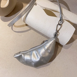Detail einer silbernen Mini-Münzgeldbörse in Croissant-Form mit Metallic-Finish und Band