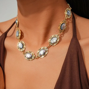 Detailed macro view of vintage oval resin links on a gold-plated baroque style necklace