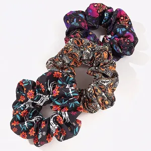 Three-piece set of Halloween themed scrunchies with pumpkin and skull prints