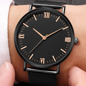 Close-up of black quartz watch with rose gold Roman numerals and mesh strap
