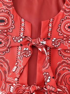 Detailed macro view of red paisley print fabric with a delicate bow tie ribbon detail