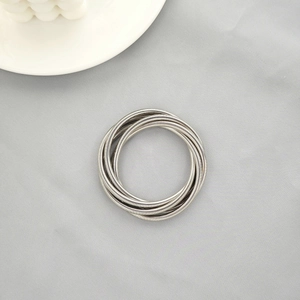 Detail of silver multi-layered spiral snake chain bracelet with metallic texture