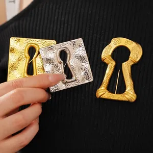 Vintage hollowed keyhole square brooch with hammered gold texture on black knitwear